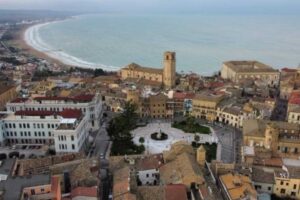 Paesaggio del paese italiano che offre cene gratuite ai turisti a marzo, con vista su strade pittoresche e ristoranti.