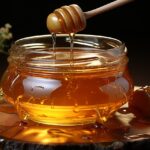 Gonfiore addominale con un barattolo di miele su sfondo bianco, simbolo della connessione tra alimentazione e benessere.