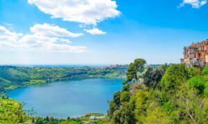 Vista panoramica di un parco naturale italiano con alberi verdi e montagne sullo sfondo.