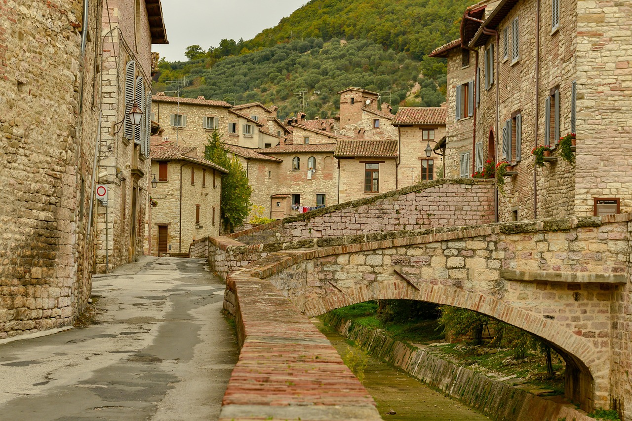 Panorama di un pittoresco borgo toscano con case in pietra e colline verdi sullo sfondo.