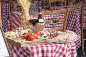 Un piatto tipico toscano con vino rosso e ingredienti freschi in un contesto rustico.